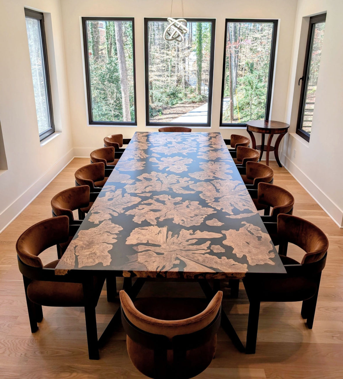 Dining room with a large floral-patterned table and wooden chairs.