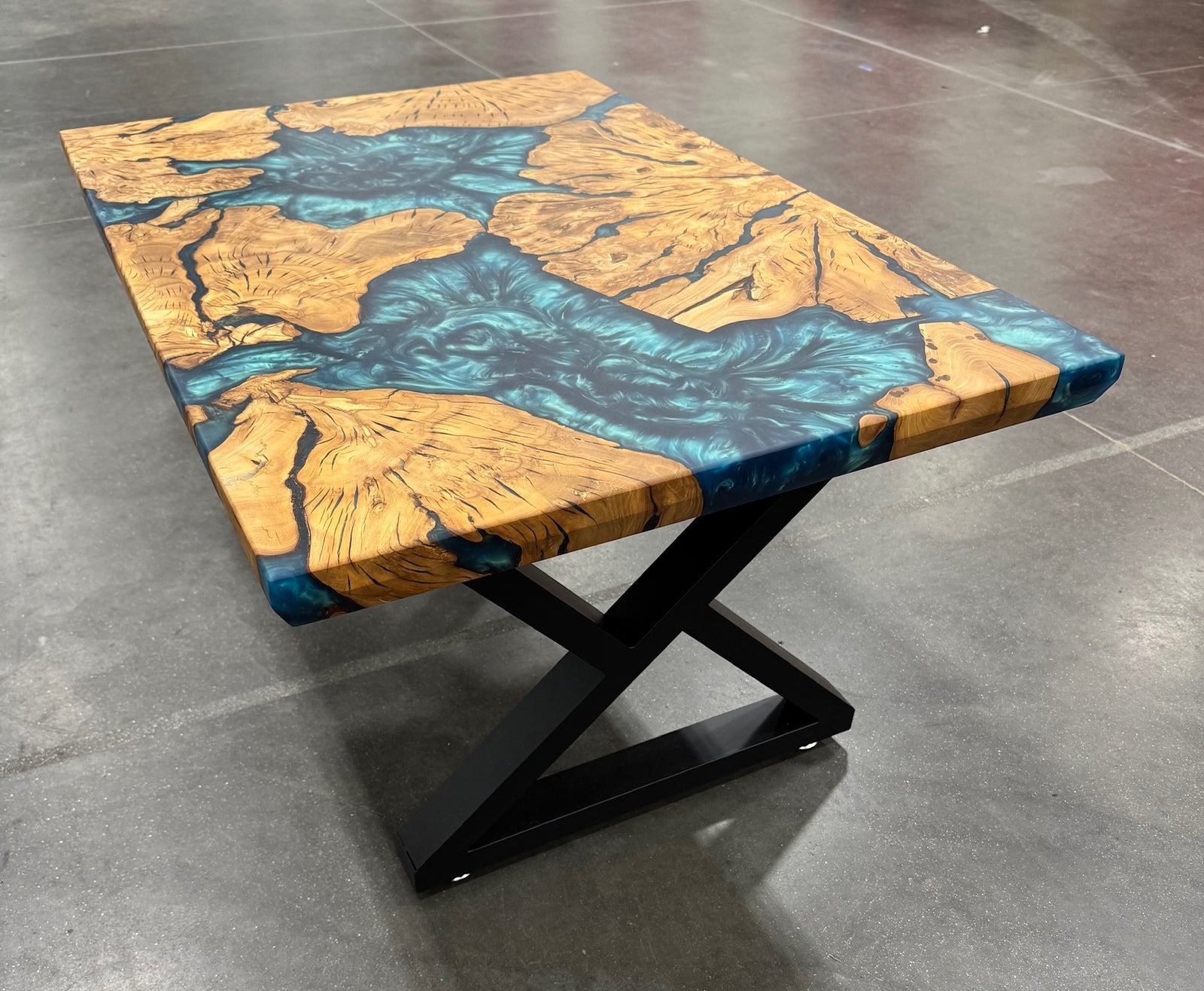 Table with a unique design featuring blue and brown patterns on a gray floor.