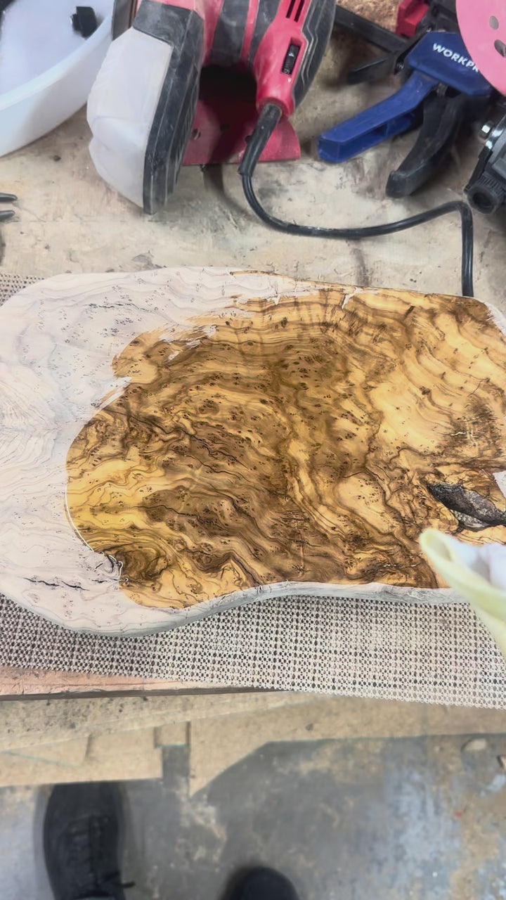 Applying finish to olive wood charcuterie board